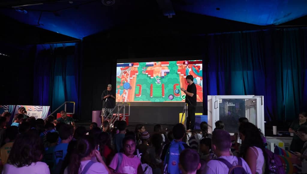 Young visitors at the barrier, filming the stage on their phones